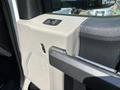 Interior door handle and controls of a 2017 Ford F-550 showing textured panel and dual buttons for window operation