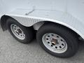 A 2016 Continental cargo trailer featuring diamond plate metal and two wheels with white rims and black tires