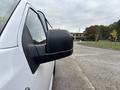 A white 2020 Ford F-150 truck with a black side mirror is shown in the foreground