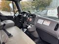 Interior view of a 2013 Freightliner 114SD featuring a driver's seat and controls including a steering wheel dashboard and gear shift