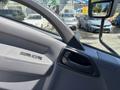 Interior view of a 2016 Isuzu NPR-HD featuring door controls and a textured door handle