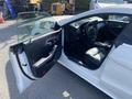A 2014 Mercedes-Benz CLA-Class with an open driver's side door showcasing the black leather interior and steering wheel.