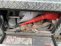 A metal toolbox filled with various tools and equipment including a red funnel gloves and a metal brush