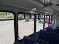 Interior view of the passenger area of a 2020 Chevrolet Express with blue fabric seats and large windows