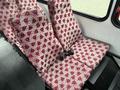 A set of red and white patterned seats inside a 2015 Ford Econoline showing a two-seat configuration with seatbelts