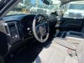 Interior view of a 2014 GMC Sierra 1500 featuring a steering wheel dashboard and center console with cup holders
