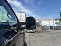 A 2022 Ford F-350 SD truck is parked with its side mirror extended towards the viewer, showcasing its large size and rugged design
