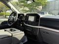 Interior view of a 2021 Ford F-150 featuring a steering wheel dashboard and touchscreen display with controls