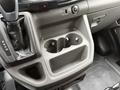Interior console of a 2020 Ford Transit featuring cup holders gear shift and control buttons