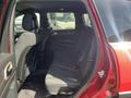 A 2015 Jeep Grand Cherokee interior showcasing the back passenger seating area with black fabric seats and no occupants