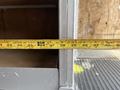 A measuring tape laid across a gray metallic surface showing measurements in inches with the tape extended to a length of approximately 42 inches