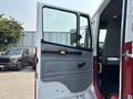 A 1999 Freightliner FL80 with its driver's side door open revealing the interior of the cab