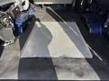 A 2011 Ford Econoline van with a flat, metallic diamond plate floor mat in the cargo area