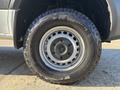 A close-up view of a 2024 Mercedes-Benz Sprinter 2500 wheel featuring a silver rim and an all-terrain tire with prominent tread patterns