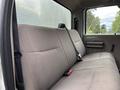 The interior of a 2010 Ford F-550 Super Duty showing a gray cloth bench seat with seatbelts and no visible passengers