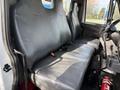 Interior view of a 2012 International DuraStar 4300 showing a gray bench seat with seatbelts and a gear shift on the floor