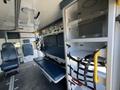 Interior view of a 2013 Chevrolet Express with two blue seating areas and storage compartments designed for emergency medical use