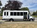 A white 2020 Chevrolet Express shuttle bus with a large side door and multiple windows