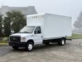 A 2019 Ford Econoline truck with a white box cargo area and a black chassis positioned on a concrete surface