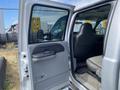 A 2007 Ford F-350 SD with the front passenger door open revealing a gray leather seat and interior details including the door handle and window control panel
