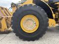 A large yellow tire of a 2012 Caterpillar 980 equipment with visible treads and a metallic rim