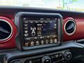 A close-up of a digital dashboard display in a 2021 Jeep Wrangler showing radio settings and various control options
