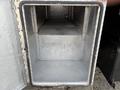 An empty metal storage compartment with a flat bottom and a step up inside designed for a 2015 Ford F-350