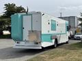A white and turquoise 2020 Freightliner MT45 delivery truck with a rear entry door and a storage compartment on the back