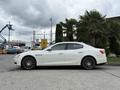 A white 2016 Maserati Ghibli with sleek lines and sporty design features prominent wheels and an elegant body shape