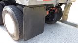 A 2003 International 5600i truck with large black mud flaps and dual rear tires showing tread patterns