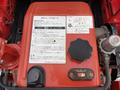 A red engine component with control dials and various labels in Japanese detailing operational instructions and specifications