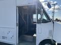 A 2012 Ford Econoline van with a visible open door and interior seating area