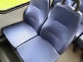 A pair of blue fabric seats from a 2019 Chevrolet Express with a textured surface and no armrests