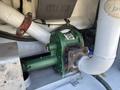 A green pump with a metal casing and various pipes attached, situated on a flat surface, part of the machinery in a 2008 Peterbilt 340 vehicle