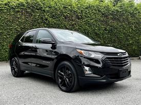 A black 2021 Chevrolet Equinox with a sleek design featuring a prominent front grille and modern headlights facing slightly to the left
