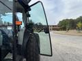 A 2009 New Holland T4020 tractor with a partially open door showcasing the interior controls and cabin space