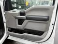 The interior door panel of a 2019 Ford F-350 SD featuring a gray and black design with a handle and control buttons