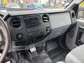 Interior dashboard of a 2013 Ford F-250 SD with controls for audio and air conditioning in a dark gray finish and textured paneling