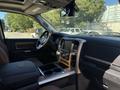 Interior view of a 2015 RAM 1500 featuring leather seats a central console with storage and cup holders and a large touchscreen display for navigation and entertainment