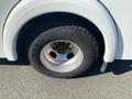 A close-up of a tire on a 2011 Chevrolet Express showing a silver wheel rim and a worn tire tread with the brand name visible