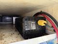 A black inverter labeled 3000 ProWatt by Xantrex with a power cord and red cables connected to it