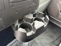 A black plastic cup holder designed to hold two cups securely in a vehicle's interior