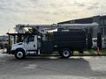 A 2012 International DuraStar 4300 bucket truck with a black storage compartment and a raised aerial lift extended from the rear
