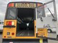 Interior view of a 2007 Freightliner B2 school bus showing seats and open rear door with signage on the inside walls