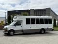 A 2020 Chevrolet Express bus with a white exterior and gray trim has large windows and a raised roof design