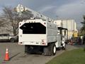 White 2011 International 4300 with a large bucket lift mounted on the rear and an enclosed compartment behind the driver's seat