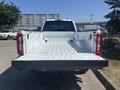 A 2023 Ford F-350 SD truck with an open bed showcasing a clean, white interior and rear tailgate positioned down
