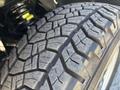 A close-up view of the tread pattern on a tire from a 2011 Chevrolet Colorado showcasing its deep grooves and rugged design