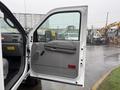 A 2006 Ford F-450 with an open driver's door showcasing the interior details and controls