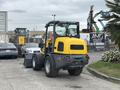 A 2014 Wacker Neuson WL34 compact wheel loader with a yellow and gray color scheme featuring a front bucket and large tires